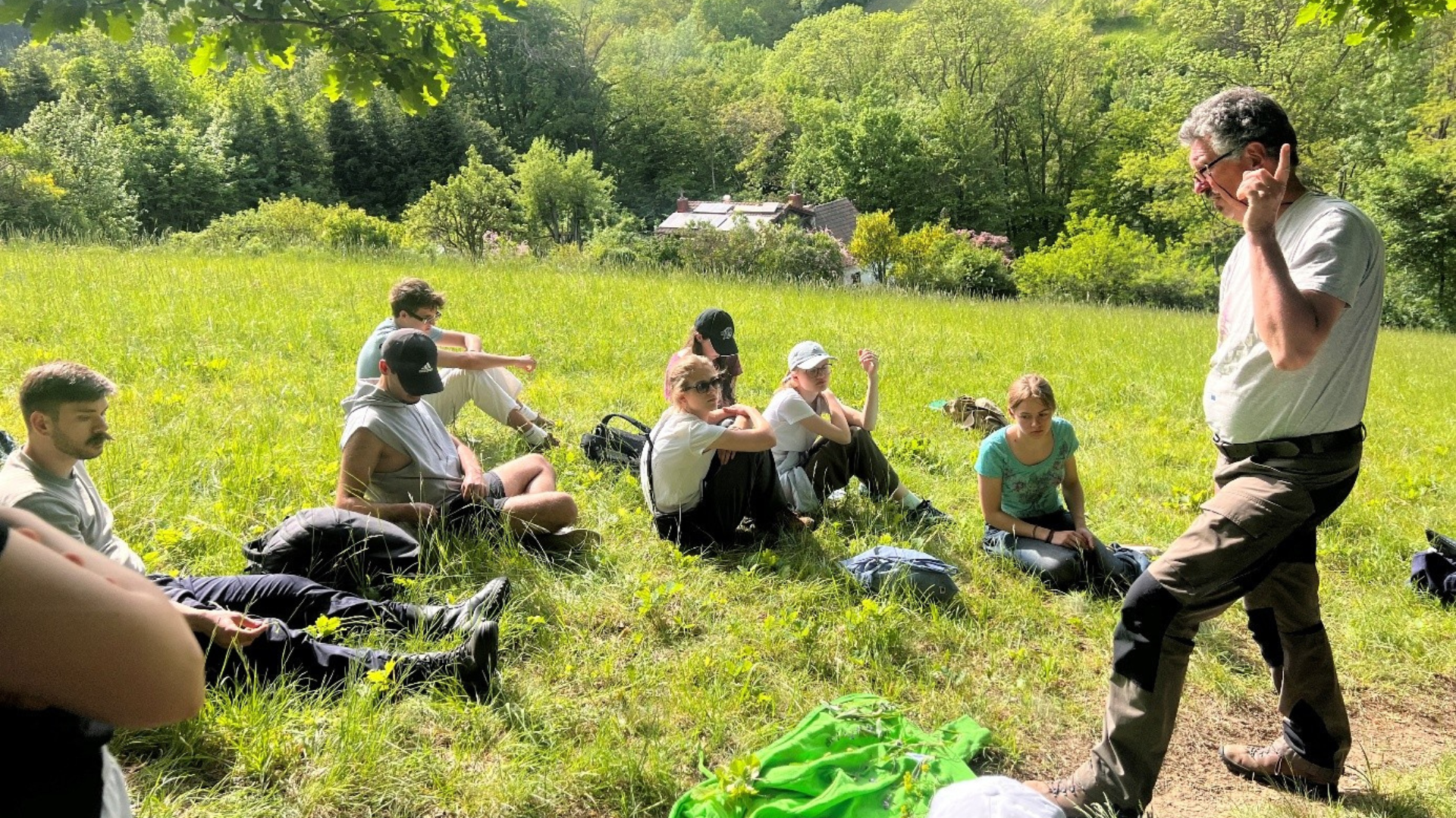 Photo of people sitting on grass (taken during the Biosphere Reserve Wienerwald seminar)